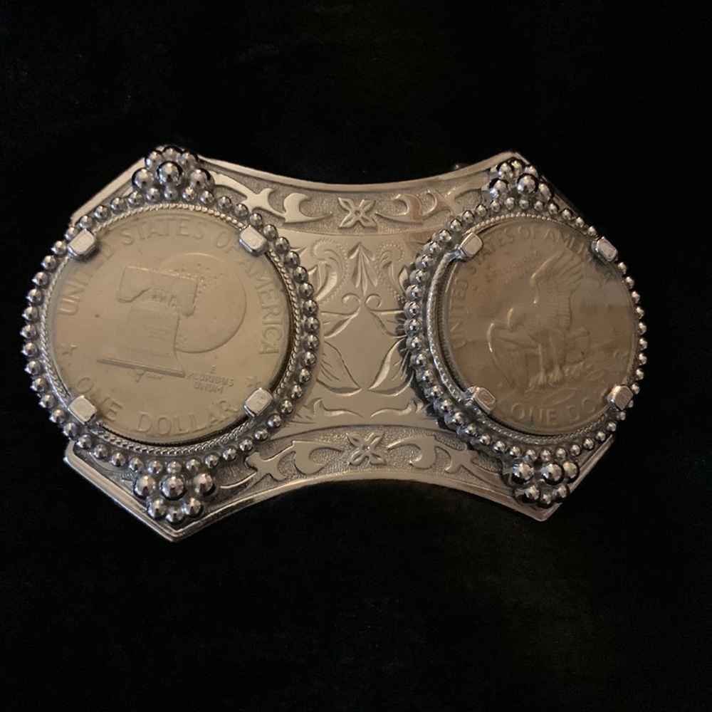 Silver belt buckle with two silver dollars. The belt buckle is very old.